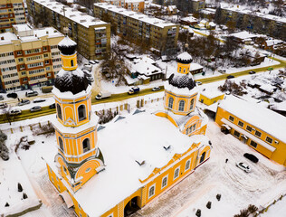 Aerial view of historic two domed building of Orthodox Cathedral of Intercession in Penza on background with modern residential area on winter day, Russia