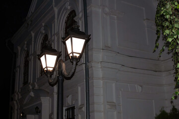 Burning street lamp on a warm evening against the background of an old house. photo