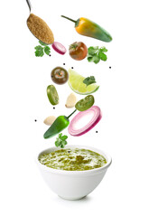 Bowl of tasty sauce with falling ingredients on white background