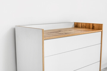 Modern chest of drawers near light wall in room