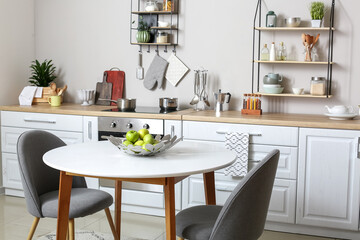 Dining table with apples in interior of modern kitchen