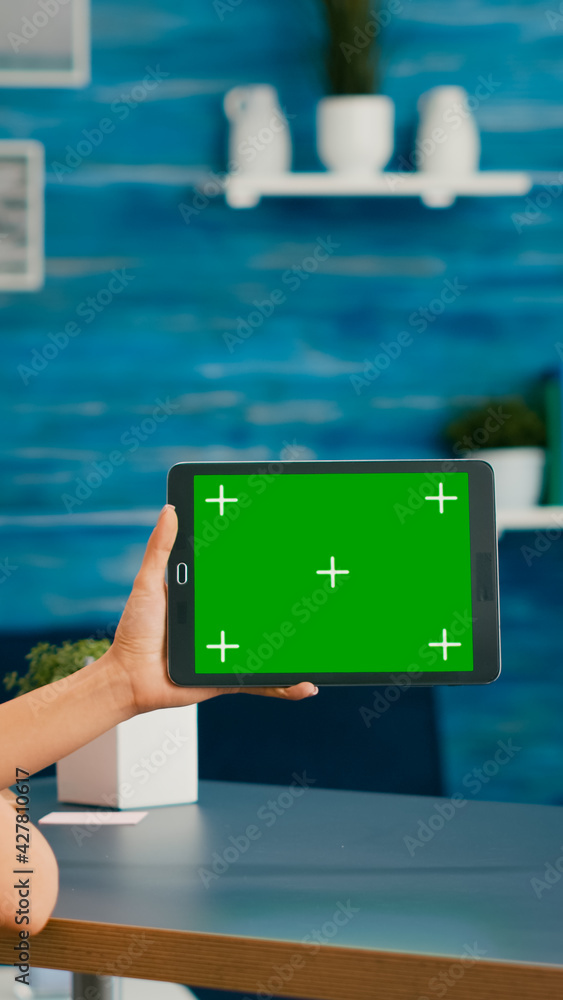 Poster woman looking at tablet computer with mock up green screen chroma key display browsing on internet s
