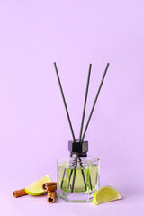 Reed diffuser with lime and cinnamon on color background