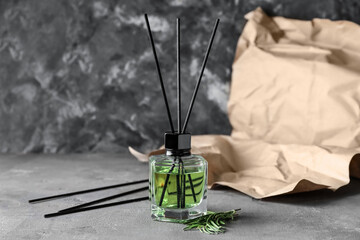 Reed diffuser with rosemary on grunge background