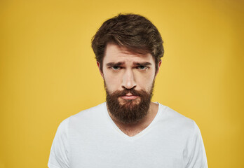 Sad men on yellow background portrait cropped view of white t-shirt