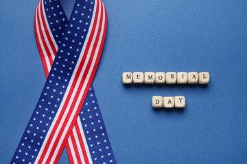 Obraz premium Text MEMORIAL DAY and ribbon in colors of USA flag on color background