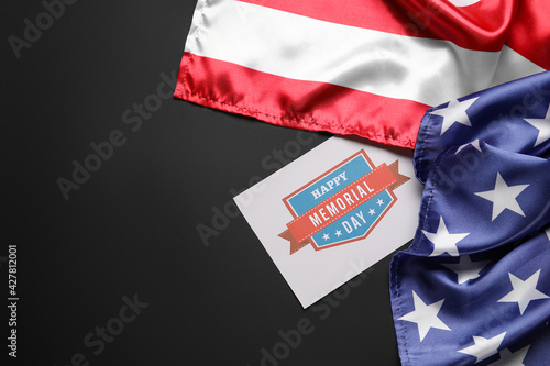 Paper sheet with text MEMORIAL DAY and USA flag on dark background