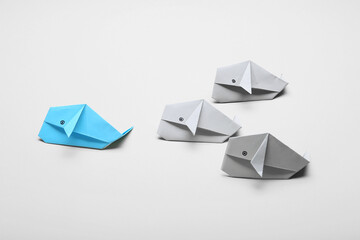 Origami whales on light background. Concept of uniqueness