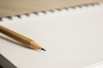 A sharp pencil with notebook on a table