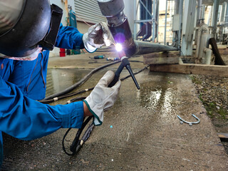 The welder is welding the steel pipe with Tungsten Inert Gas Welding process (TIG). The welder...