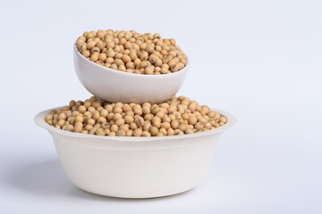 Soybean seeds in a bowl and cup on white background, Food ingredients