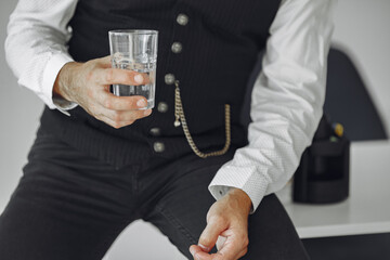 Handsome old businessman sitting with glass of water