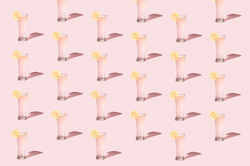 Creative pattern made with refreshing drink on a pastel pink background. Minimal summer concept.
