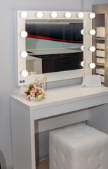 Beautiful white makeup table with light bulbs.
