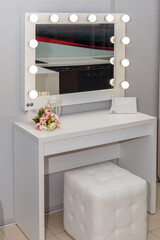 Beautiful white makeup table with light bulbs.