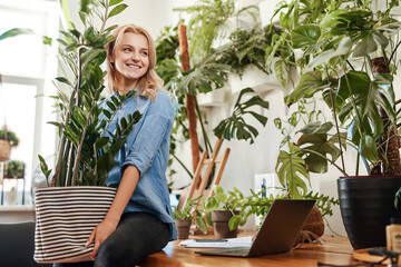 Ecofriendly businesswoman furnishing her place of work with houseplant