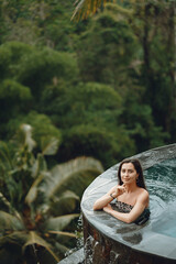 Woman in a swimming pool on a jungle view
