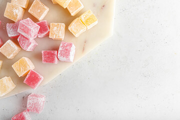 Board with Turkish delight on light background