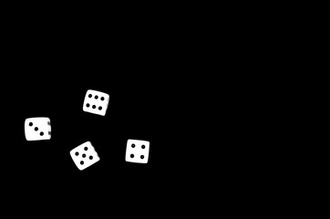 Top view of four dice on black background with space for text