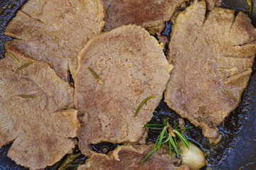 Roast beef with garlic and rosemary in a pan