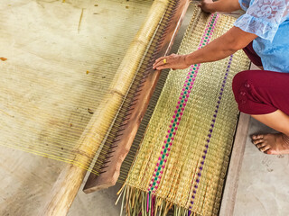The hands of women woven mats traditional are products handmade in countryside of Thailand.