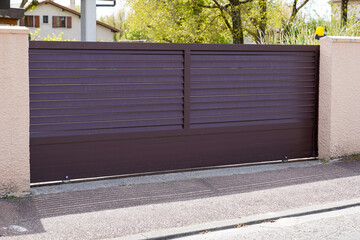 Metal portal brown driveway entrance gates slide house access garage in suburb