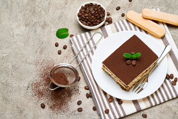 Portion of Traditional Italian Tiramisu dessert and coffee beans on grey concrete background
