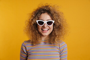 Naklejka premium Happy young casual woman with fizzy hairstyle standing