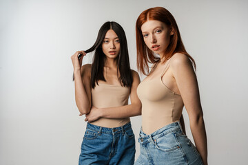 Two young multiethnic women standing posing together