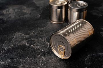 Closed food tin cans on dark background