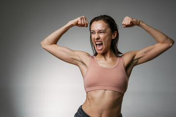 White woman wearing brassiere screaming while showing her biceps