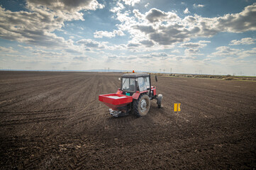 Fototapeta premium Tractor spreading artificial fertilizers