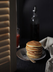 Sweet Homemade Stack of Pancakes with Butter and Syrup for Breakfast isolated on black background