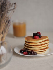 Sweet Homemade Stack of Pancakes with Butter, berries and Syrup for Breakfast 
