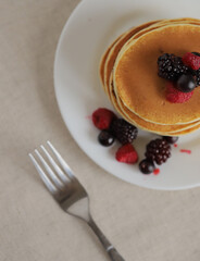 Sweet Homemade Stack of Pancakes with Butter, berries and Syrup for Breakfast 