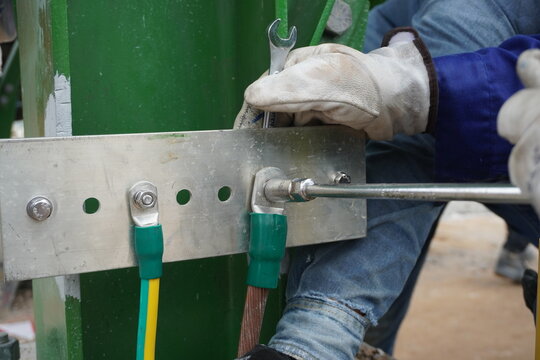 Electrical high voltage ground copper bar on wall drilling installation in part of industry for control system.