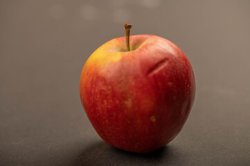 A fresh red apple on a black background.