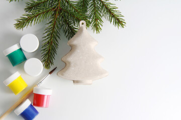 Christmas toy Christmas tree made of papier-mache (paper), gouache, brushes on a white background.The concept of preparing for Christmas, a master class on making Christmas toys for children.Copyspace