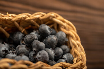 Fresh blueberries in a wicker basket on a wooden table. Harvest, village breakfast.