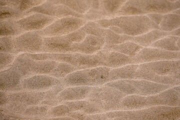 Fototapeta na wymiar Sand texture background. Nature created shapes. Warm tone. Nobody. Abstract background