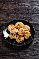 sesame lamb patties on a black plate