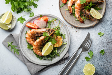 grilled tiger prawns with vegetables on a ceramic plate, top view