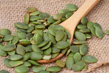 Raw pumpkin seeds on hemp sackcloth  and wood spoon organic food  ingredients