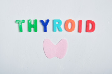cut out from felt thyroid gland and inscription from plastic letters thyroid gland on gray background, thyroid awareness month concept
