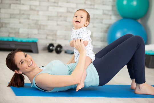 young mother does physical exercises with her baby