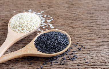 Black (Poppy) and white sesame seeds in wooden spoon on wooden background,Copy space,Close up.