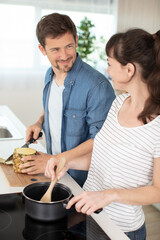 smiling young couple cooking food in the kitchen