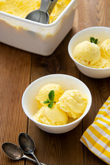 Vanilla ice cream scoops sundae in bowl on wooden background