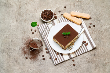 Portion of Traditional Italian Tiramisu dessert and coffee beans on grey concrete background