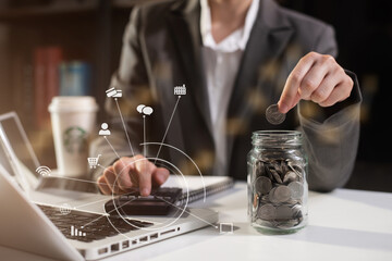 Business woman holding coins putting in glass with using  calculator to calculate concept saving money for finance accounting.